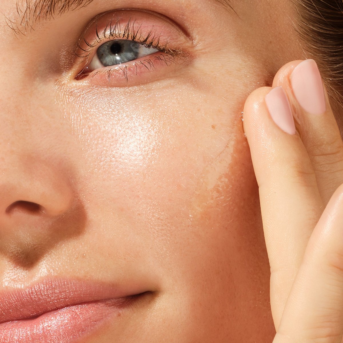 Close up of model applying the Brightening Serum