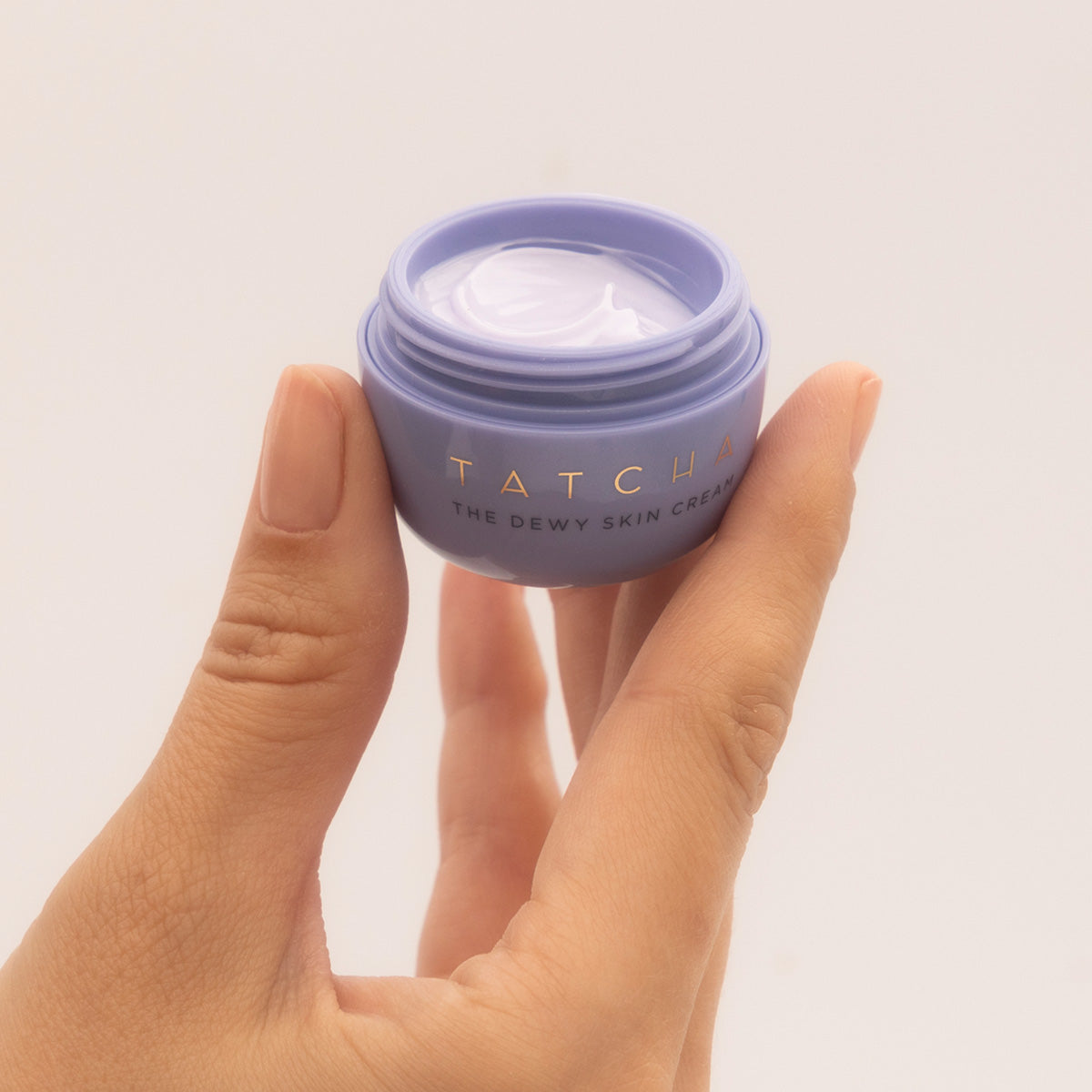 Hand holding Dewy Skin Cream Mini