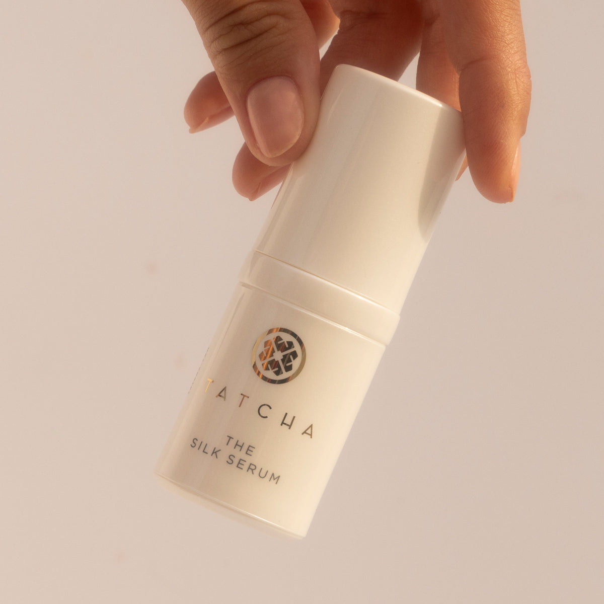 Hand holding the mini Silk Serum