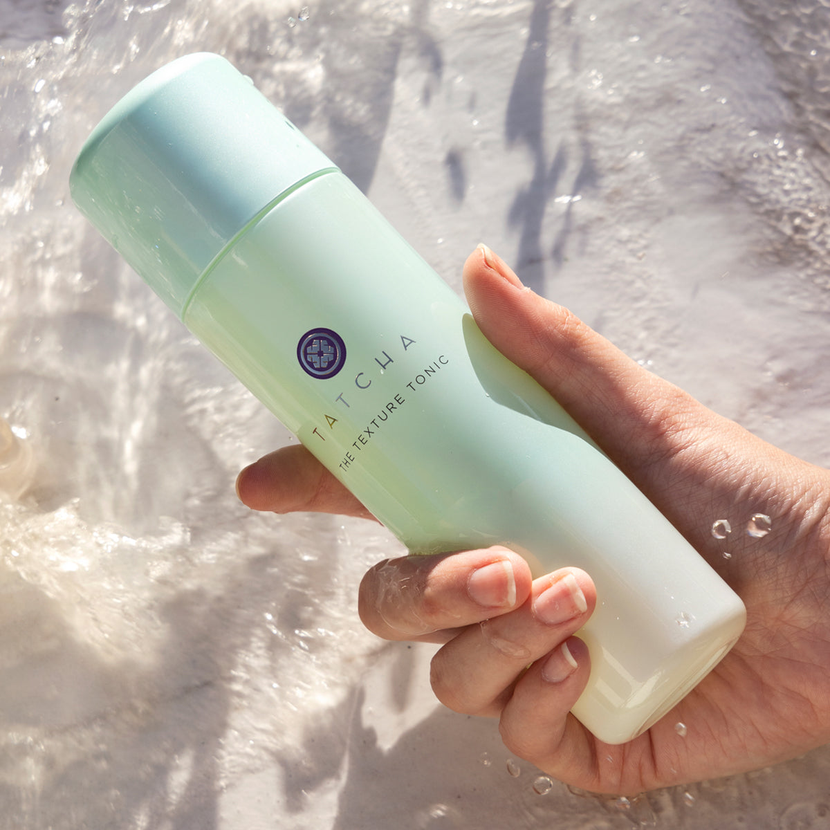 Hand holding the Texture Tonic over water