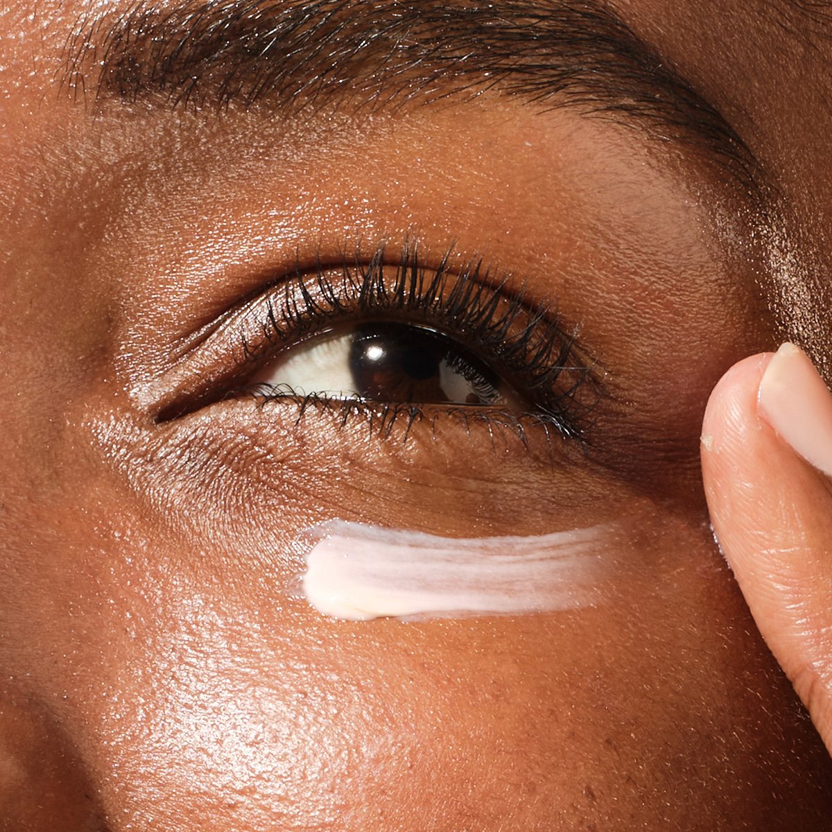 Model applying The Brightening Eye Cream