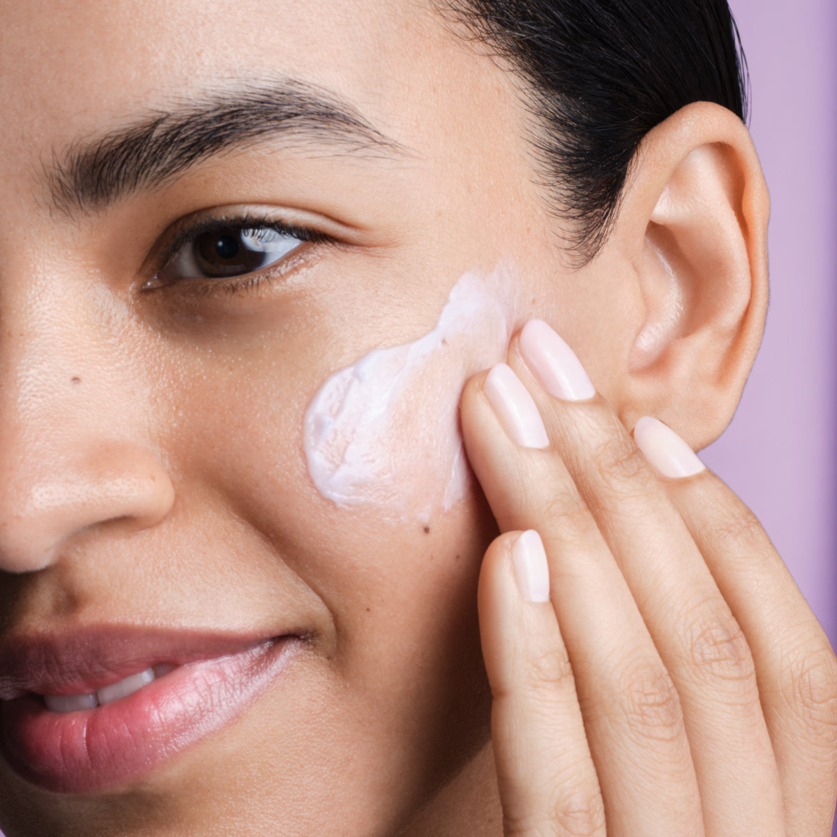 Model applying Dewy Skin Cream