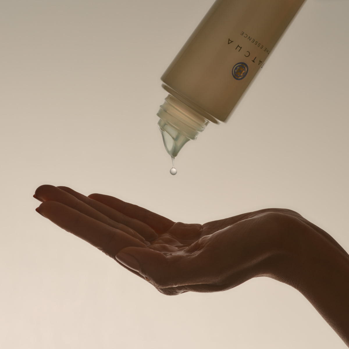Hand pouring the Tatcha Essence