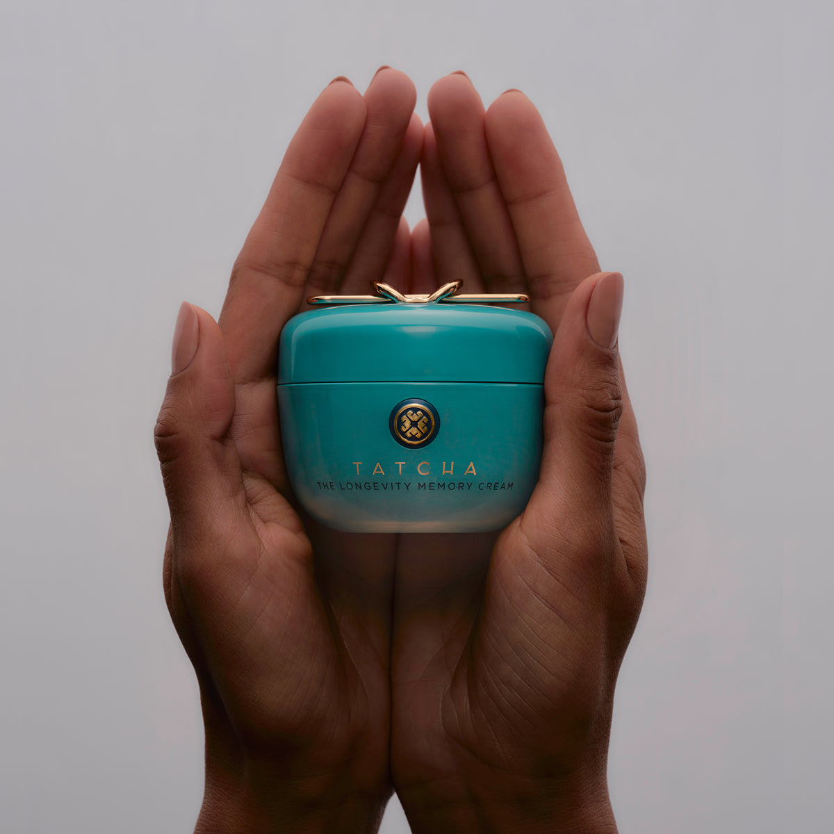 Hands holding the Tatcha Longevity Memory Cream