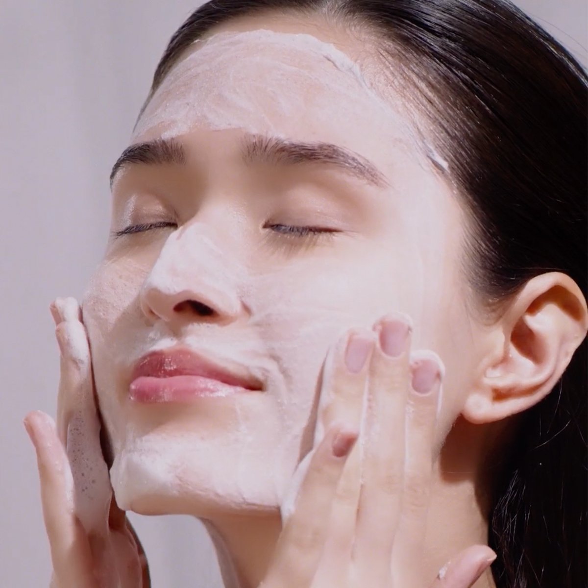 Woman washing face with Rice Polish Classic
