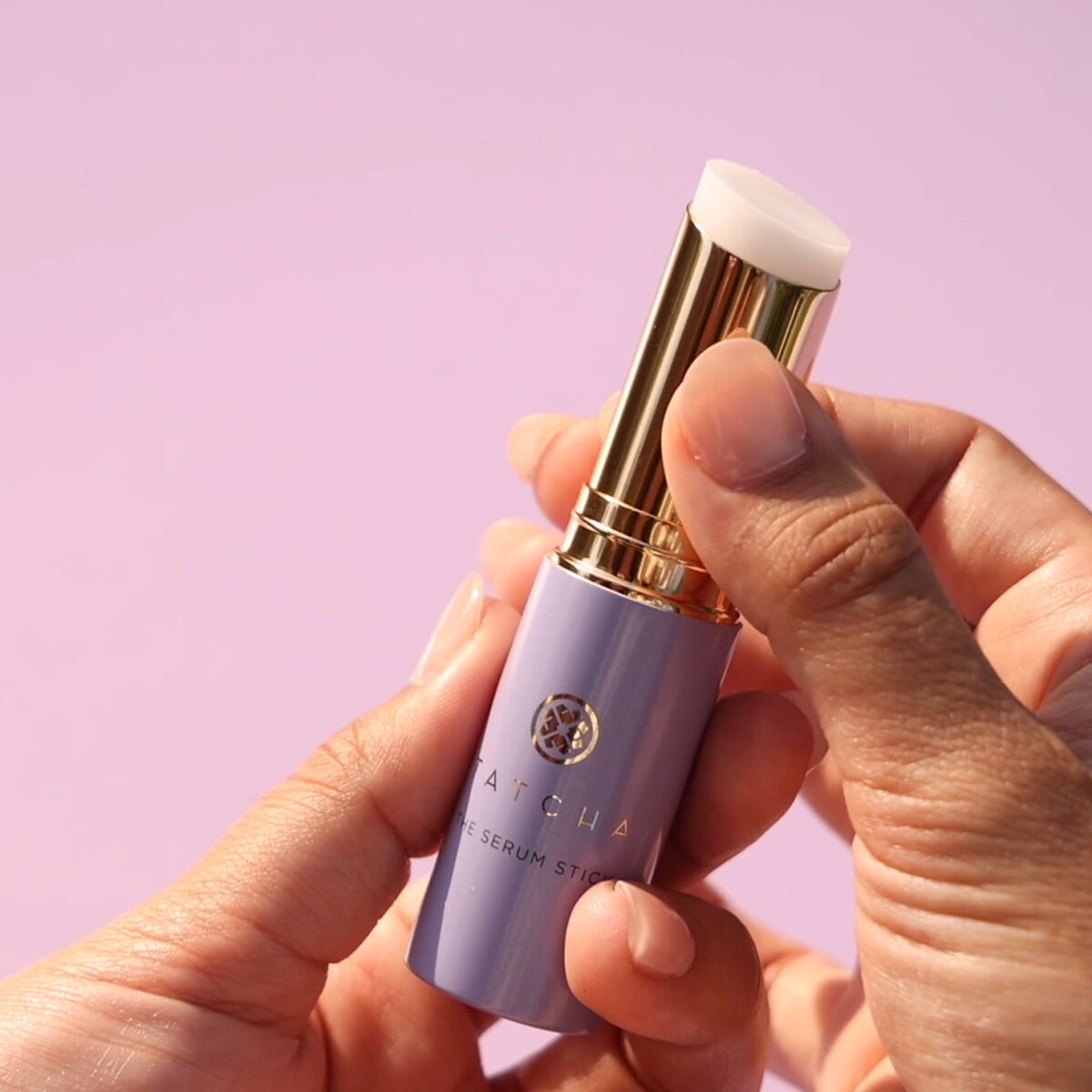 Shot of model twisting The Serum Stick applicator.