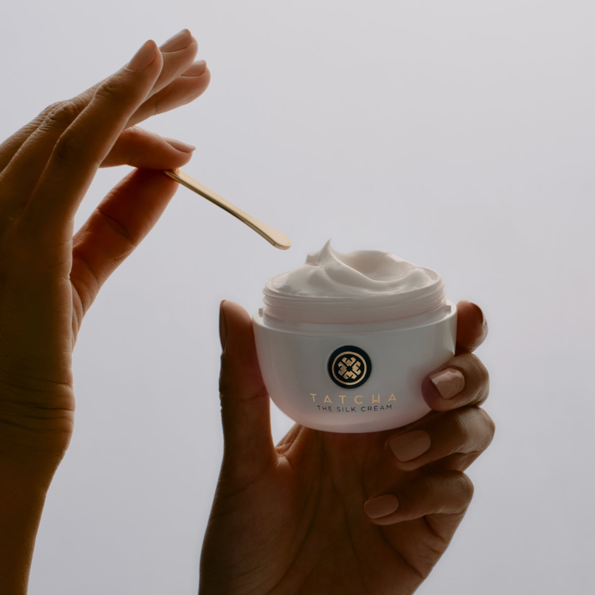 Hands holding the Tatcha Silk Cream