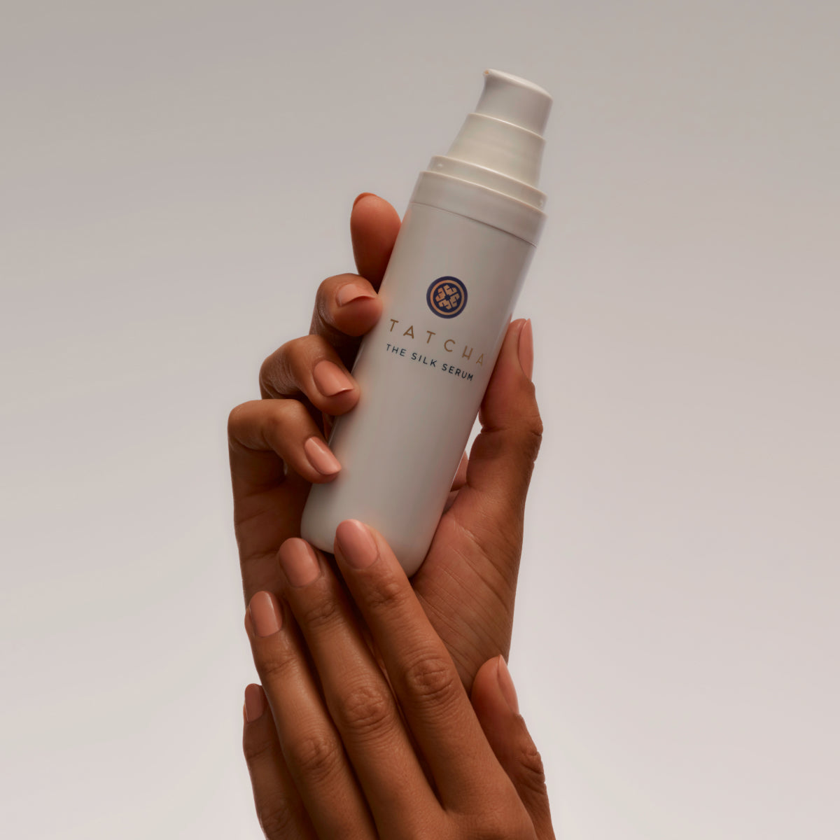 Hands holding the Tatcha Silk Serum