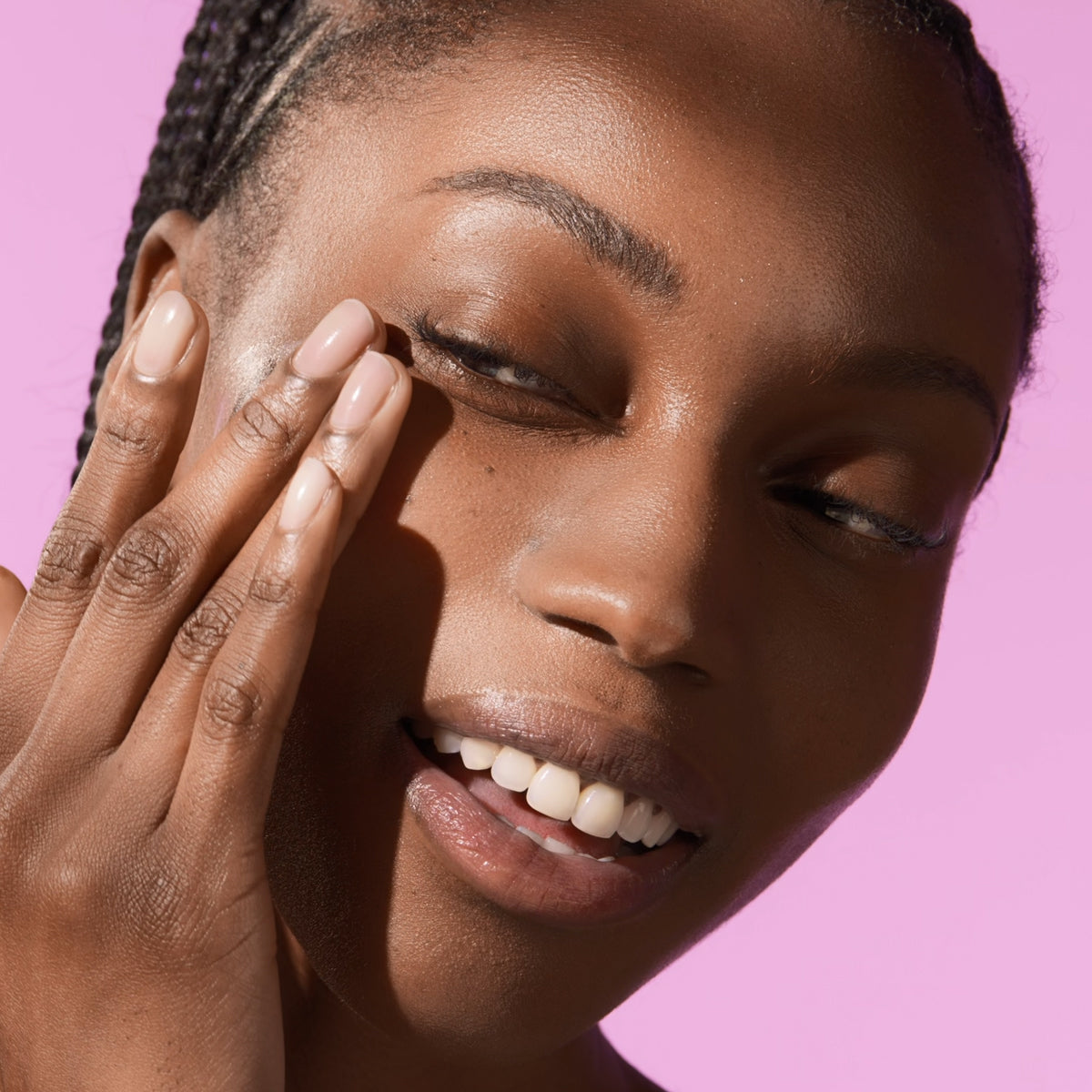 Shot of model applying The Silk Sunscrreen SPF 50 on face.
