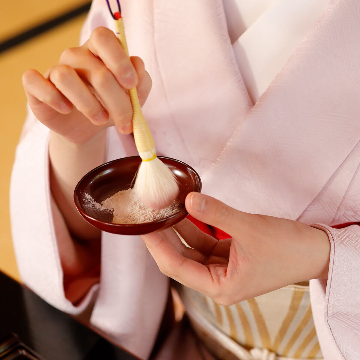 Shot of model brushing into bowl of The Silk Powder.