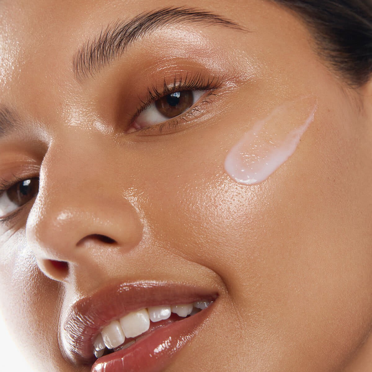 Close up of woman with The Dewy Milk Moisturizer on face