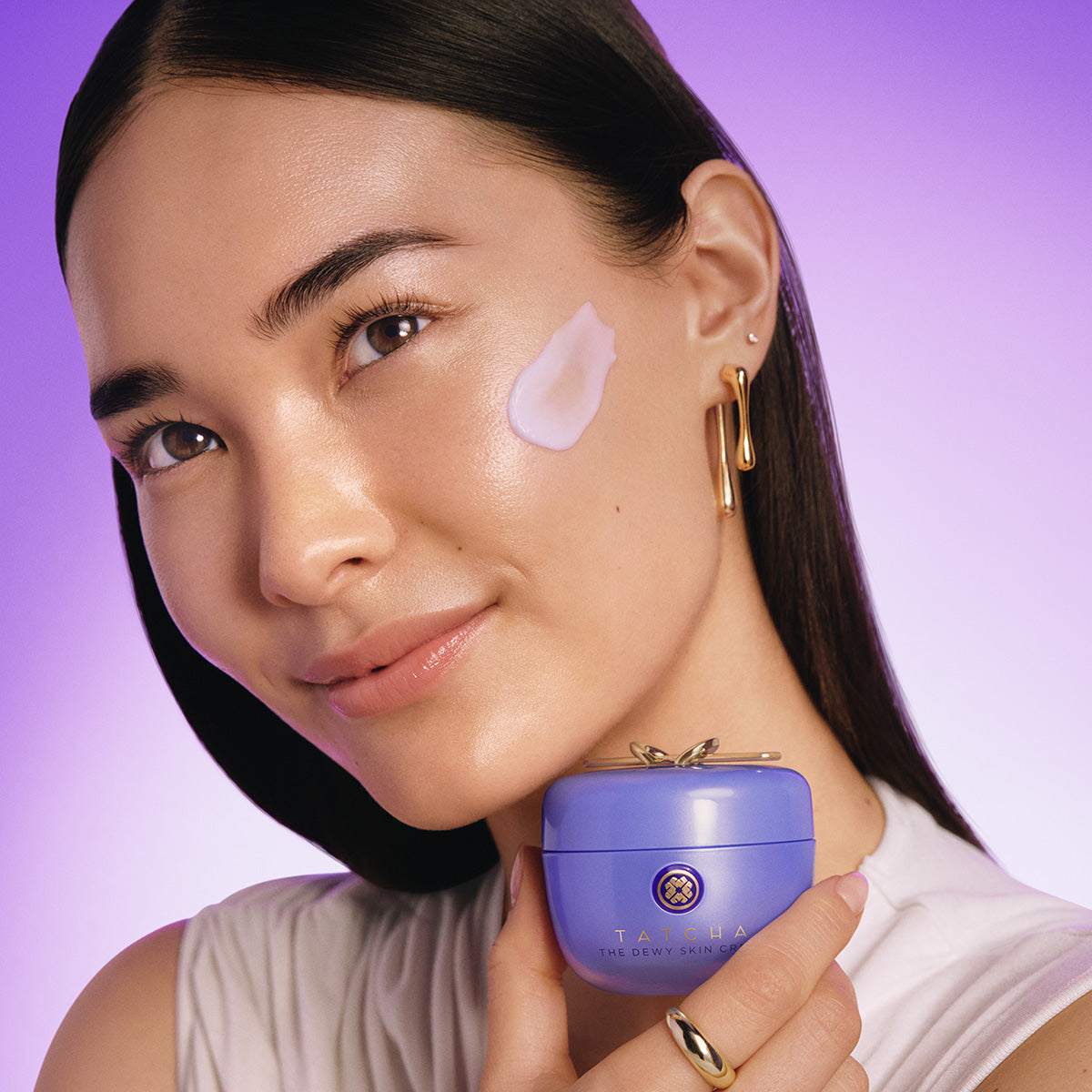 woman applying Tatcha dewy skin cream to face
